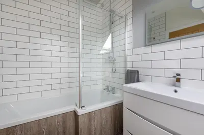 a white bathroom with a tub and a sink at 4 Bed in Saham Toney oc-o30348 in Saham Toney
