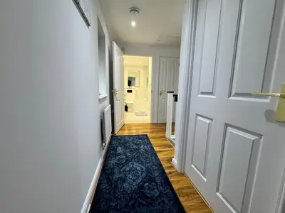 a hallway with a white door and a blue rug at A luxurious coach house in Colchester