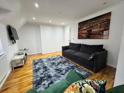 a living room with a couch and a tv at A luxurious coach house in Colchester