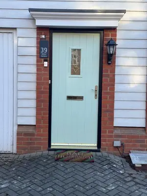 a white door on a brick house with a window at A luxurious coach house in Colchester