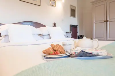 a breakfast tray with croissants and fruit on a bed at Compass Barn, Wenhaston in Wenhaston