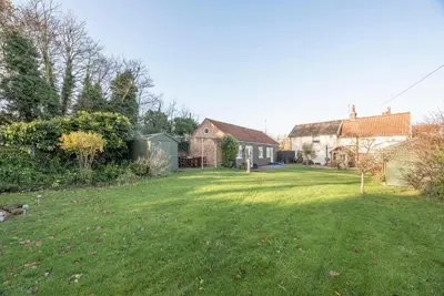 a yard with a house and a grassy field at Compass Barn, Wenhaston in Wenhaston