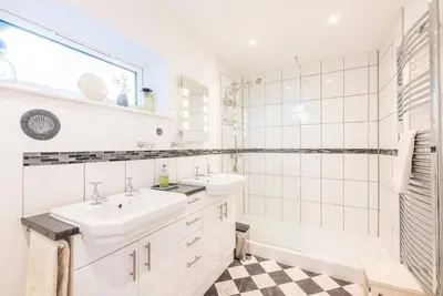 a white bathroom with a sink and a tub at Compass Barn, Wenhaston in Wenhaston