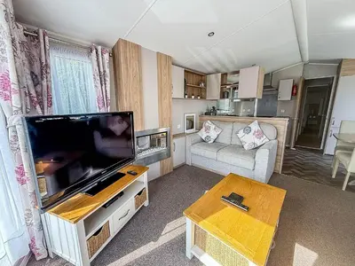 a living room with a large flat screen tv at Beautiful Caravan With Decking & Wifi At Carlton Meres Park Ref 60002R in Saxmundham