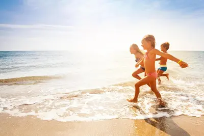 a group of children playing on the beach at Beautiful Caravan With Decking & Wifi At Carlton Meres Park Ref 60002R in Saxmundham