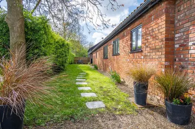 a brick house with a garden with plants in a yard at East Wing at Champaignes Toft, Mendlesham in Stowmarket