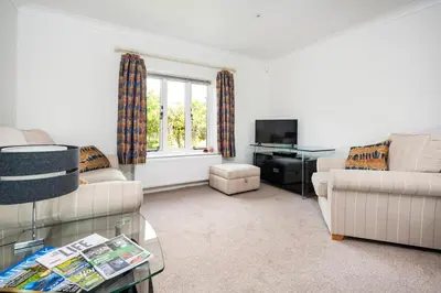 a living room with two couches and a tv at East Wing at Champaignes Toft, Mendlesham in Stowmarket