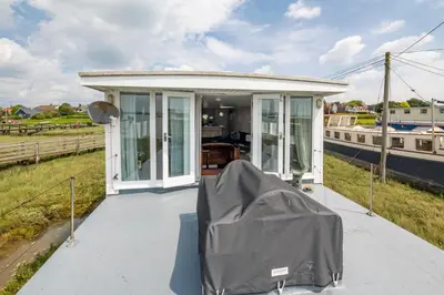 a small house with a cover over it on a boat at Lorna, Houseboat , West Mersea in West Mersea