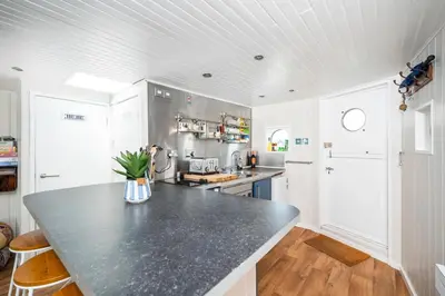 a kitchen with a large black counter top at Lorna, Houseboat , West Mersea in West Mersea