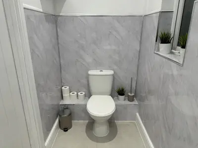 a bathroom with a toilet with plants in it at Private cinema studio guest house with garden in Brentwood
