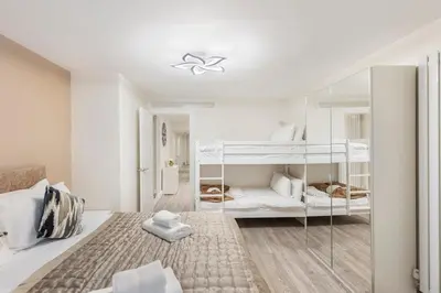 a white bedroom with two bunk beds in it at Modern 2 Bed Gem Southend on Sea Free parking in Southend-on-Sea
