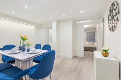 a dining room with a table and blue chairs at Modern 2 Bed Gem Southend on Sea Free parking in Southend-on-Sea