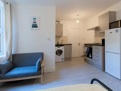 a living room with a blue couch in a kitchen at Studio flat in Heart of Southend - Pass the Keys in Southend-on-Sea