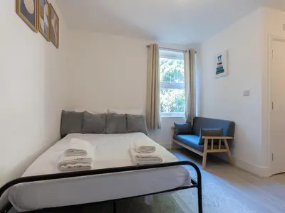 a bedroom with a bed and a blue chair at Studio flat in Heart of Southend - Pass the Keys in Southend-on-Sea