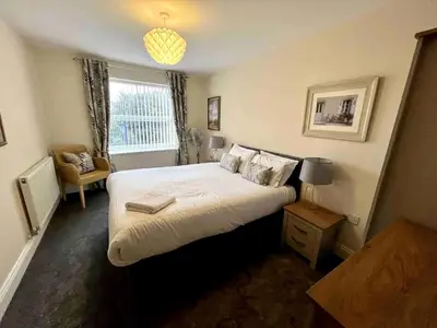 a bedroom with a large bed and a window at Modern 2 Bedroom Apartment with Sea view in Felixstowe