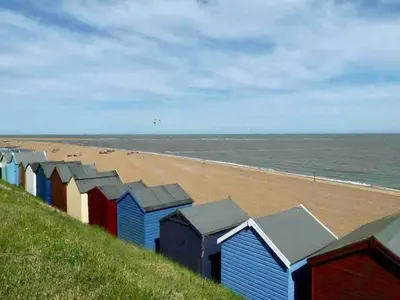 a row of colourful beach huts on a beach at Modern 2 Bedroom Apartment with Sea view in Felixstowe