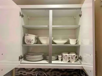 a cabinet filled with plates and cups and dishes at Modern 2 Bedroom Apartment with Sea view in Felixstowe