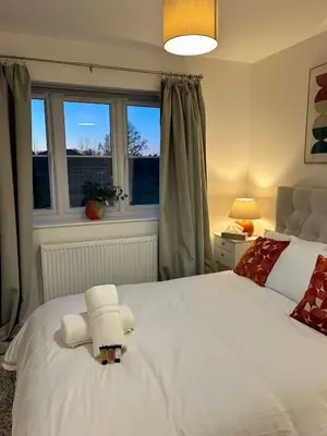 a bedroom with a white bed with a towel on it at The Belles' Place near Colchester in Earls Colne