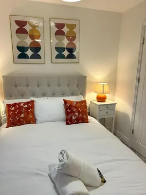 a bedroom with a large white bed with red pillows at The Belles' Place near Colchester in Earls Colne