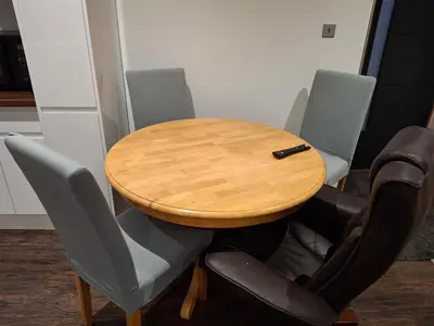a wooden table and chairs with a pen on top at Hazel Cottage in Mildenhall