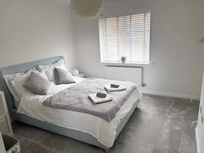 a white bedroom with a bed with two dishes on it at Detached Place to stay in Essex in Witham