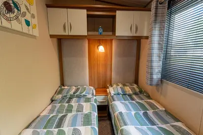 two beds sitting next to each other in a room at Caravan Hire Mersea Island - EOEPS in East Mersea