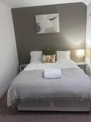 a bedroom with a large bed with two night stands at Delightful-Ipswich Suffolk-4 Bed-SelfCatering-Contractor-Parking-Wifi in Copdock
