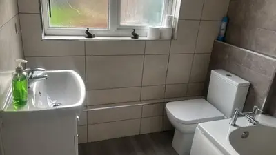 a bathroom with a sink and a toilet and a window at Delightful-Ipswich Suffolk-4 Bed-SelfCatering-Contractor-Parking-Wifi in Copdock
