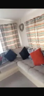 a couch with pillows in a room with windows at 911 Caravan in Saint Osyth