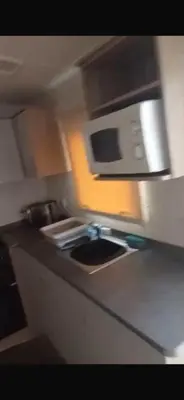 a kitchen with a sink and a microwave at 911 Caravan in Saint Osyth