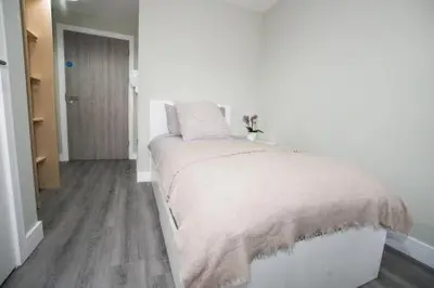 a white bedroom with a bed in a room at Ryegate House Colchester in Colchester