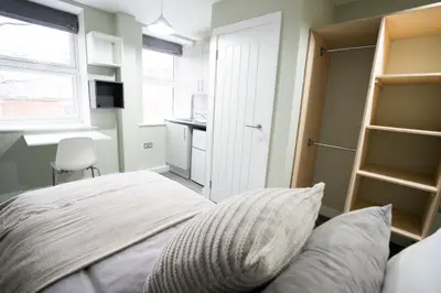 a bedroom with a bed and a desk and a window at Ryegate House Colchester in Colchester