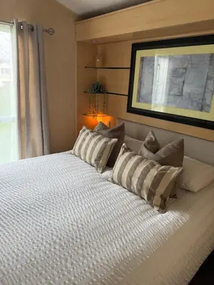 a bedroom with a large white bed with pillows at Stylish Inviting 2 Bedroom Caravan with Sea View in East Mersea