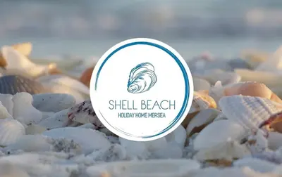 a sign on a pile of shells on a beach at Stylish Inviting 2 Bedroom Caravan with Sea View in East Mersea