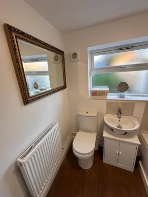 a bathroom with a toilet and a sink and a mirror at 3 bedroom house Colchester in Colchester