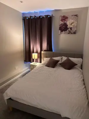 a bedroom with a white bed with a blue light at 3 bedroom house Colchester in Colchester