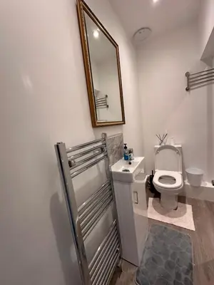 a white bathroom with a toilet and a mirror at 3 bedroom house Colchester in Colchester