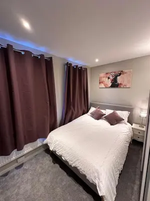 a bedroom with a bed with brown curtains at 3 bedroom house Colchester in Colchester