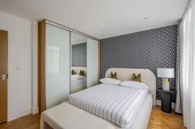 a bedroom with a white bed and a mirror at Luxurious City Centre Apartment in Chelmsford with Sky TV, Sports, Movies & Netflix in Chelmsford