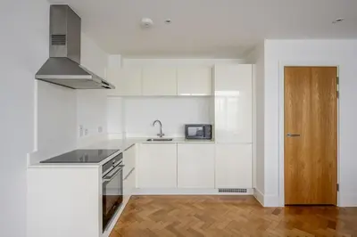 a white kitchen with a sink and a microwave at Luxurious City Centre Apartment in Chelmsford with Sky TV, Sports, Movies & Netflix in Chelmsford