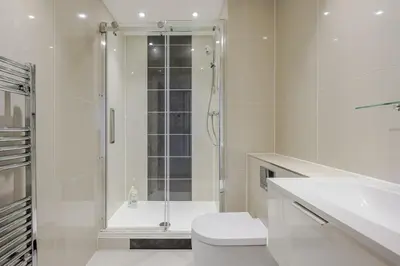 a white bathroom with a shower and a toilet at Luxurious City Centre Apartment in Chelmsford with Sky TV, Sports, Movies & Netflix in Chelmsford