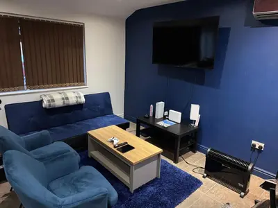 a blue living room with a couch and a table at Secret Escape in Cherry Hinton