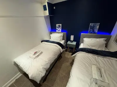 two twin beds in a room with blue lights at Secret Escape in Cherry Hinton