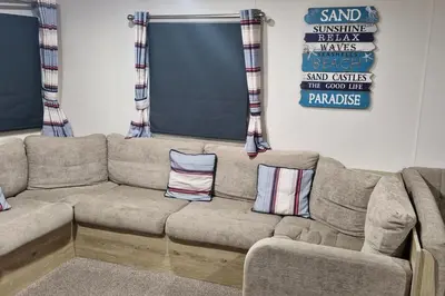 a couch in a living room with two pillows on it at Highfield Grange Holiday Park in Clacton-on-Sea