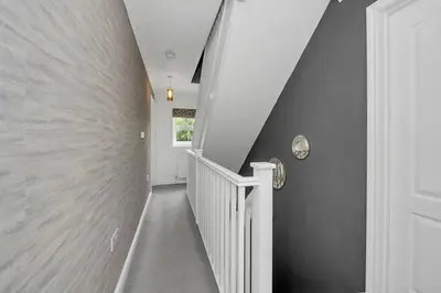 a staircase in a house with a white stair case at Spacious 5 Bedroom Detached Property with parking in Bury Saint Edmunds
