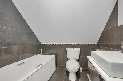 a bathroom with a tub and a toilet and a sink at Spacious 5 Bedroom Detached Property with parking in Bury Saint Edmunds