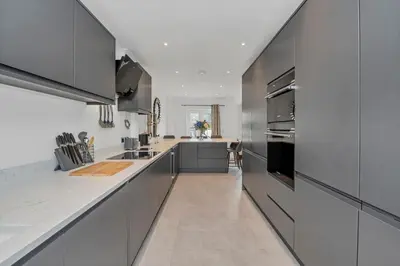 a kitchen with gray cabinets and a white counter top at Spacious 5 Bedroom Detached Property with parking in Bury Saint Edmunds