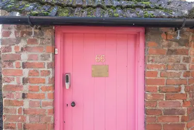 a pink door with the number six on it at The Book Nook, Woodbridge in Woodbridge
