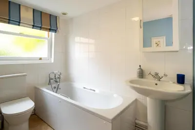 a bathroom with a tub and a sink and a toilet at Barleys Cottage - Aldeburgh Coastal Cottages in Aldeburgh