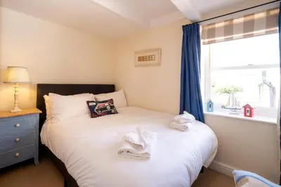 a bedroom with a bed with towels on it at Barleys Cottage - Aldeburgh Coastal Cottages in Aldeburgh